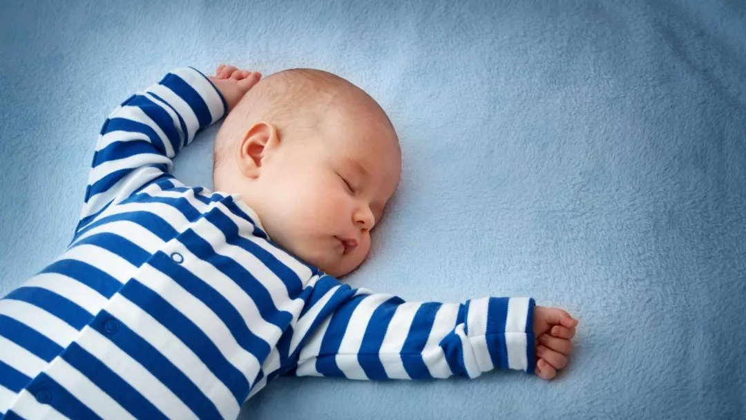 A person holding a baby, representing holistic sleep coaching.