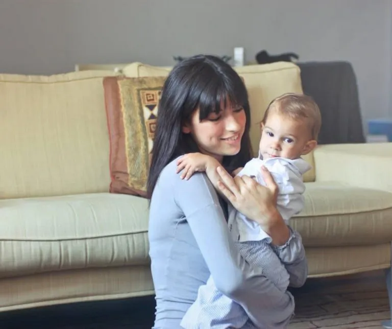 A baby being held upright, possibly due to reflux