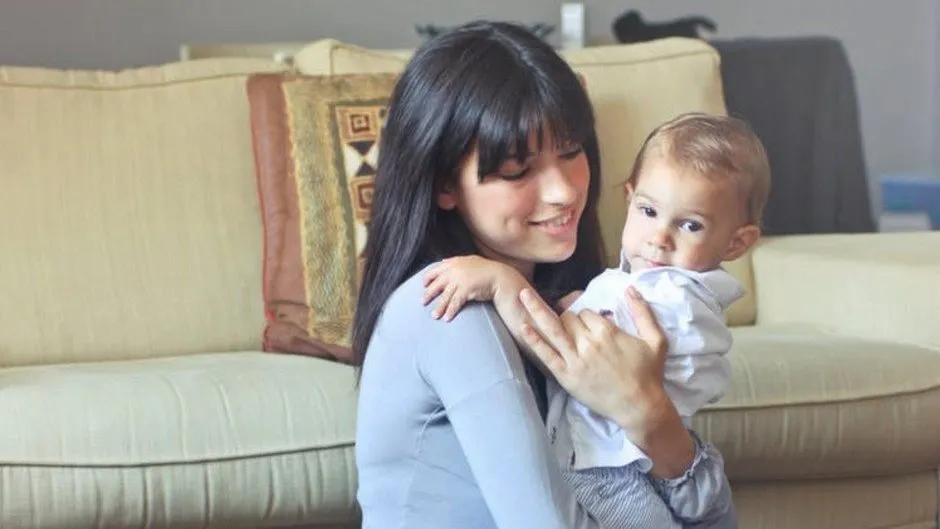 A person holding a baby, depicting a holistic approach to sleep coaching.
